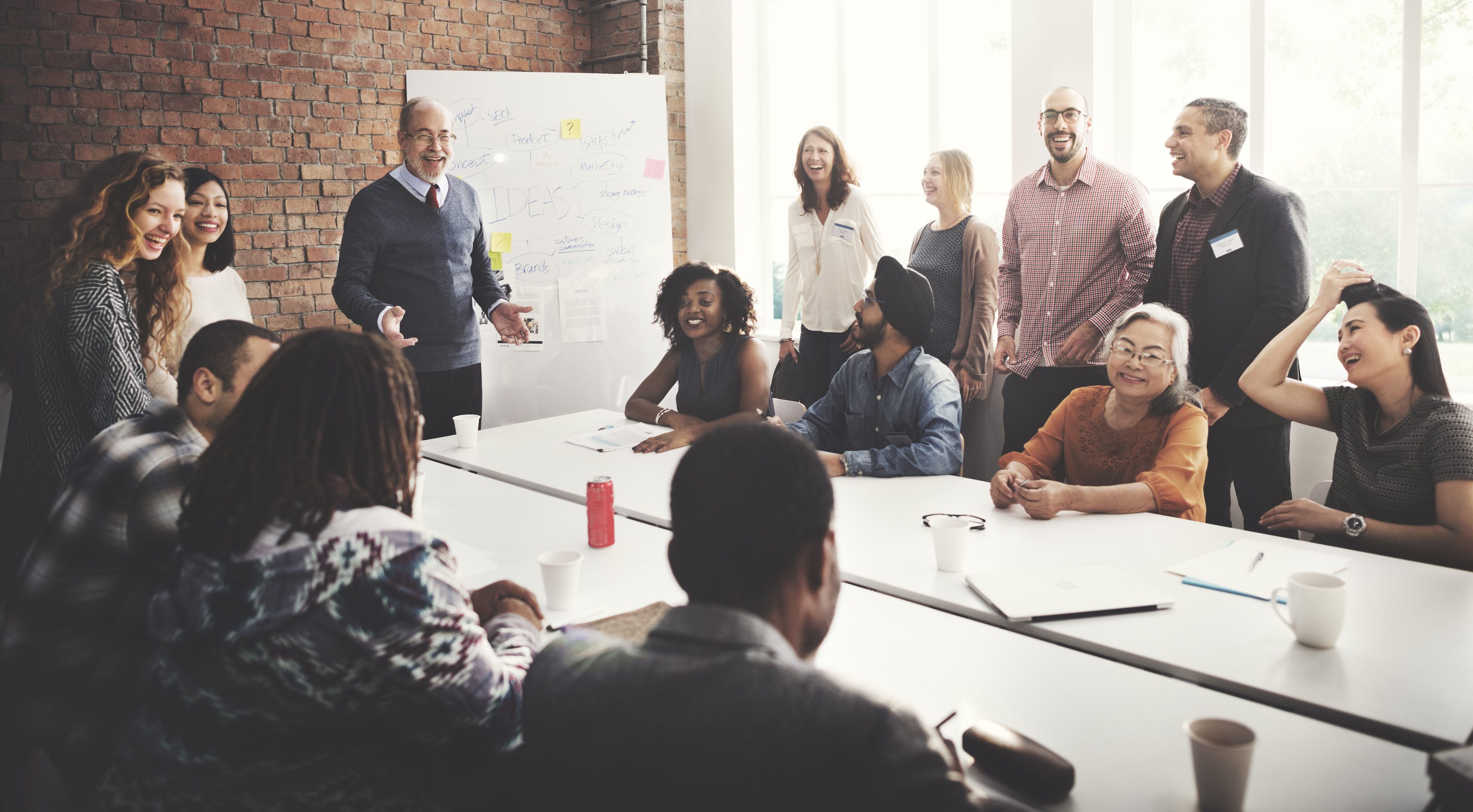 A meeting in an office, where some employees are seen smiling